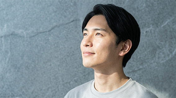 上を向いて微笑んでいる男性の画像